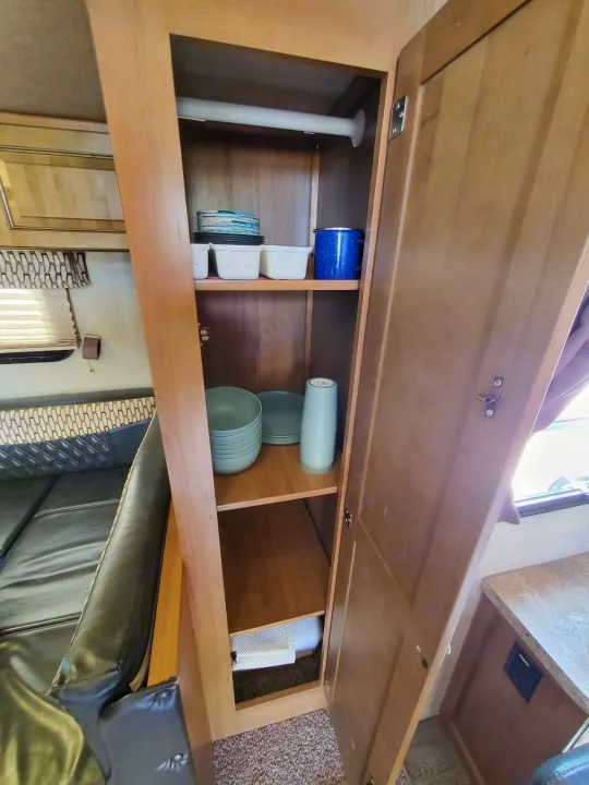 RV rental interior: A well-stocked cabinet with dishes, bowls, and cups for practical use.. Forest River Rockwood Mini Lite 2017