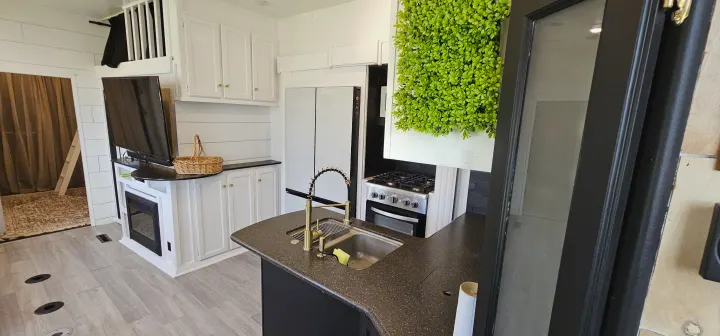 Spacious RV rental interior: modern kitchen with full-size fridge & stove, cozy living area with fireplace & loft access.. Heartland Edge 2016