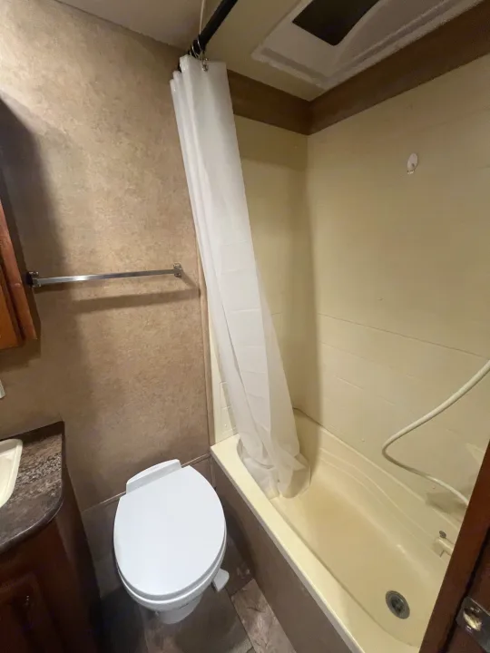 RV rental bathroom with a compact toilet, tub/shower combo, and vanity, designed for small travel spaces.. Jayco Jay Flight 2013