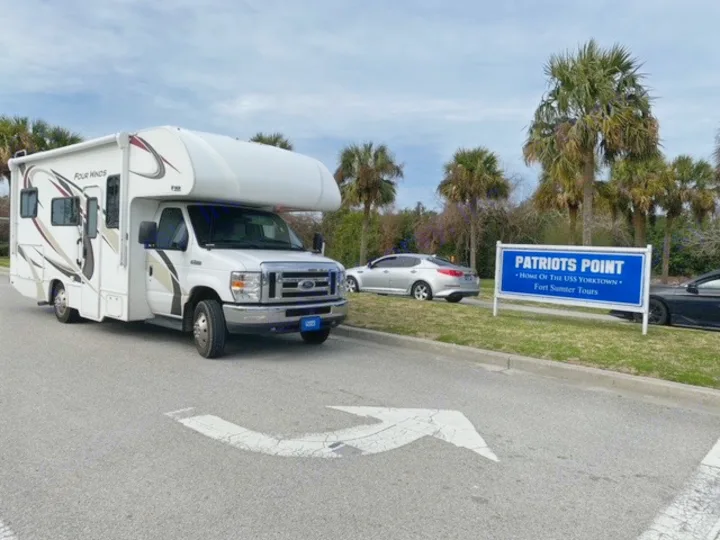 White Four Winds RV rental at Patriots Point, home of USS Yorktown & Fort Sumter tours. An arrow points left on asphalt.. Thor Four Winds 2020