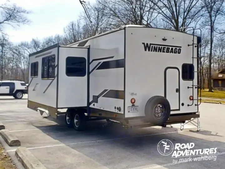 This white Winnebago travel trailer, with its slide-out extended, is parked for an rv rental adventure or camping trip.. Winnebago Minnie 2801BHS 2024
