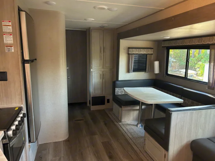 Spacious RV rental interior featuring a bright dinette, kitchen, fridge, and ample storage for comfortable travel.. Coachmen Catalina Legacy 2022