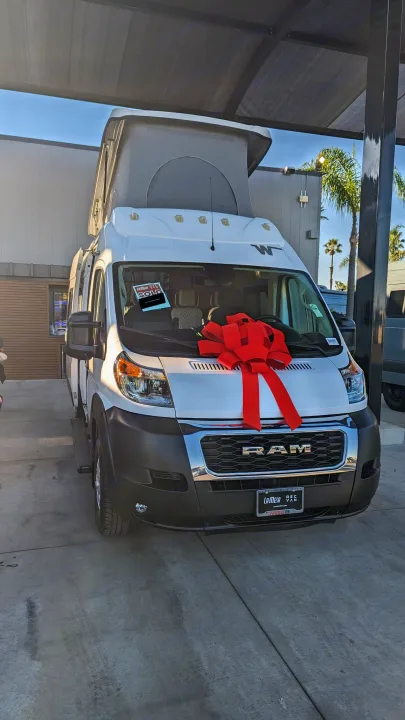 White Ram camper van, a common RV rental choice, sports a festive red bow.. Winnebago Solis 59PX 2023