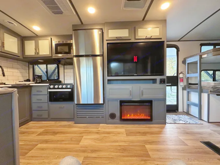 Spacious RV rental interior featuring a modern kitchen, cozy living area with TV, and convenient bunk beds.. Keystone RV Bullet Premier Ultra Lite 2022