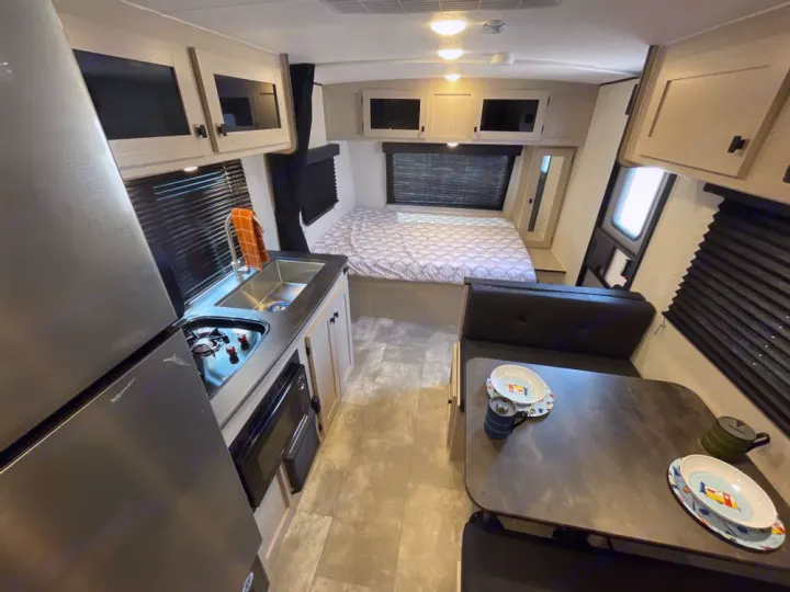 Explore this RV rental's cozy interior: a compact kitchen, dinette, and rear bed offer comfort for your adventures.. Coachmen Apex Nano AAPT186BH 2024