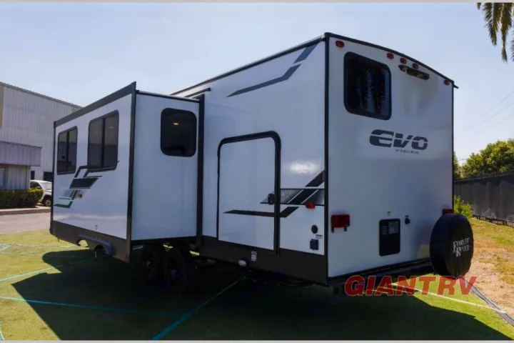 White EVO Forest River travel trailer with extended slide-out, perfect for your next rv rental adventure. Outdoor view.. Forest River Evo CSJT2650G 2023