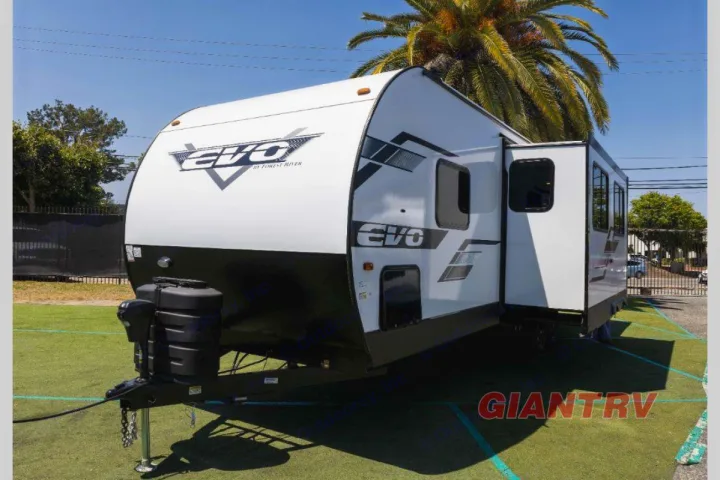 White Forest River EVO travel trailer with a slide-out extended, ideal for rv rental. Sunny outdoor scene.. Forest River Evo CSJT2650G 2023
