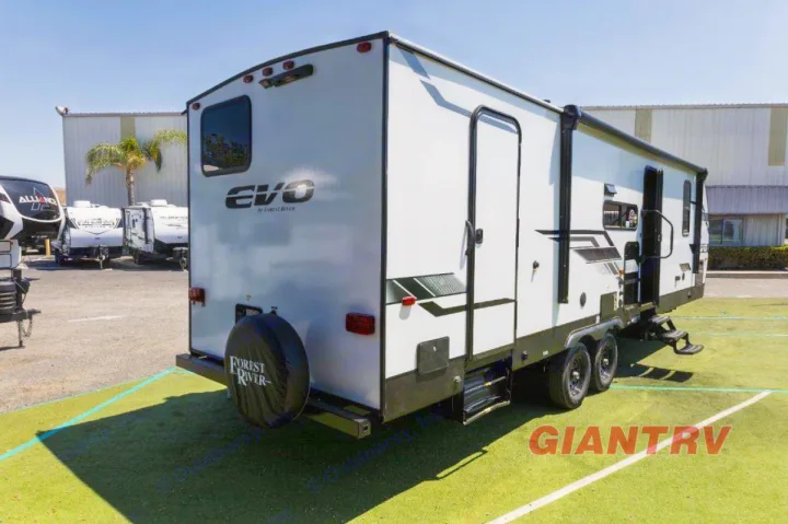 This white Forest River EVO travel trailer is ready for your next rv rental adventure, parked on green turf.. Forest River Evo CSJT2650G 2023