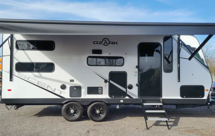Bright white Ozark Ascent RV rental, a travel trailer with black features, extended awning, and dual wheels. Ready for adventure.. Forest River ozark 2440bhkx 2024