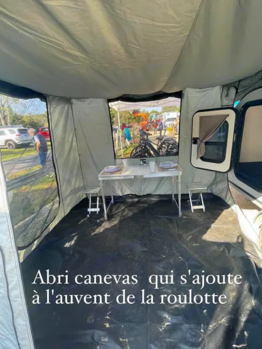 RV rental with a comfy canvas annex for dining. Features a table, stools, and outdoor views of bikes & people.. Car-gotrailers liberty2goXL 2021