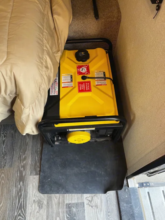 A portable generator is dangerously stored inside an RV rental near a bed, posing a serious carbon monoxide risk.. Keystone Hideout 2021