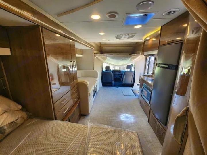 Spacious rv rental interior, featuring a full kitchen, comfortable bedroom with protective covers, and front living area.. Entegra Coach Qwest 24L 2024