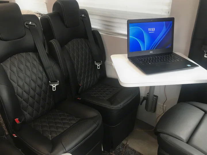 RV rental interior featuring plush seating, laptop on table, and convenient power. Perfect for travel & work.. Mercedes-Benz Sprinter 2022