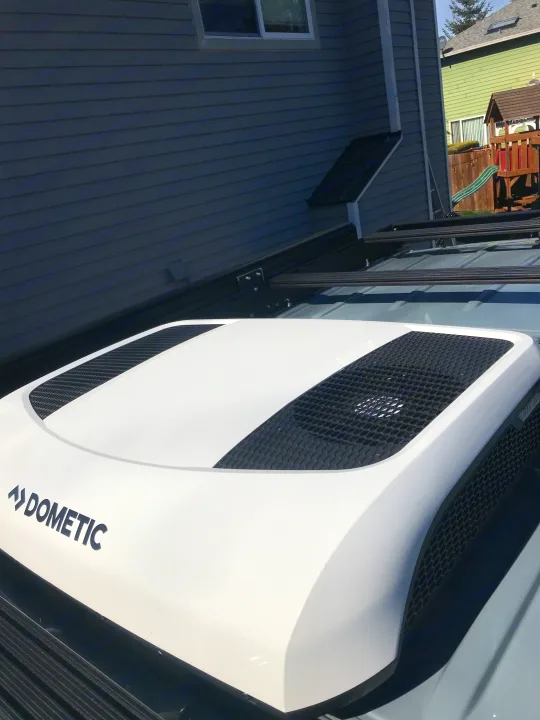 Close-up of a white Dometic rooftop AC unit on an RV rental, providing cool comfort for your travels.. Mercedes-Benz Sprinter 2022