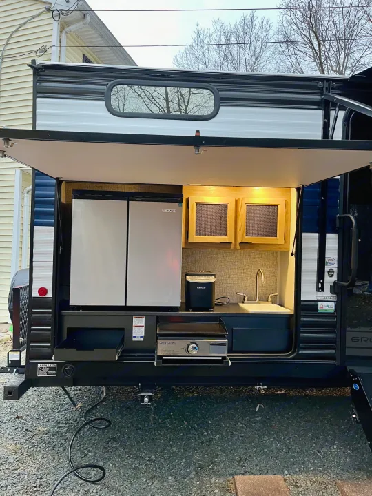 RV rental with an outdoor kitchen: fridge, sink, pull-out griddle, and ice maker, perfect for adventures.. Forest River Grey Wolf 29TE 2024