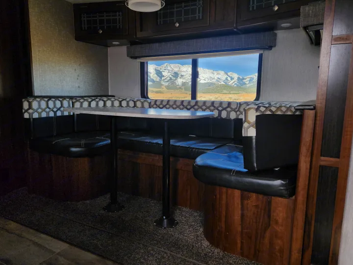 Cozy RV rental dinette with a stunning mountain view, perfect for travel and camping.. Heartland Wilderness 2019