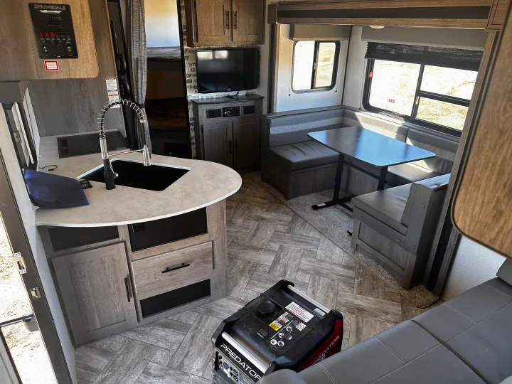 RV rental interior showcasing a kitchenette, dinette, bunks, control panel, and portable generator.. Keystone RV Springdale 2021
