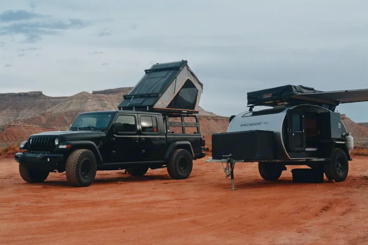 Off-road RV rental adventure: Jeep Gladiator with open rooftop tent & teardrop trailer with awning, in a desert.. Escapod Escapod Trailer 2022