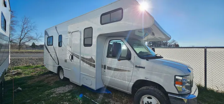 White Class C RV rental, an E-350 motorhome, parked on grass. Sunny day, ready for your next adventure.. Thor Majestic 2014