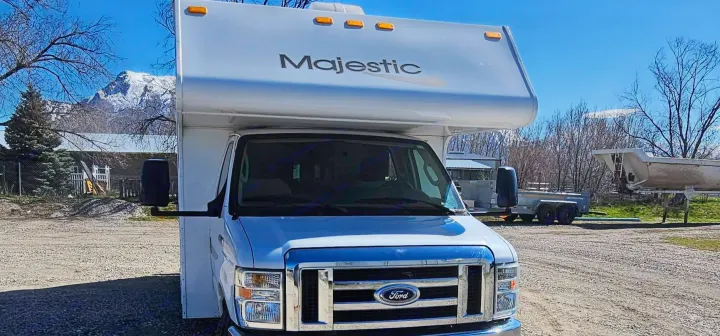 Majestic Ford RV rental parked on gravel. Snow-capped mountains and trees set the scene for your outdoor adventure.. Thor Majestic 2014