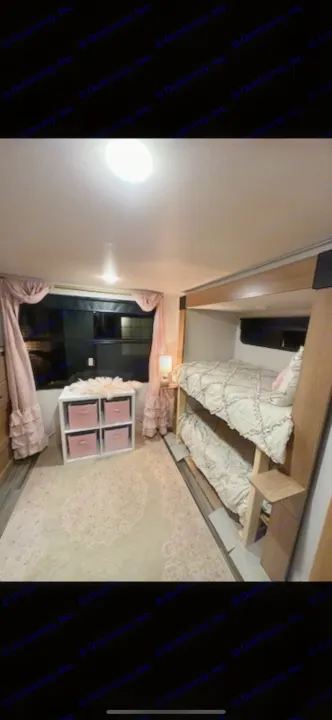 Cozy RV rental bunk room featuring ruffled beds, pink curtains, and a patterned rug.. Primetime Sanibel 3602WB 2023