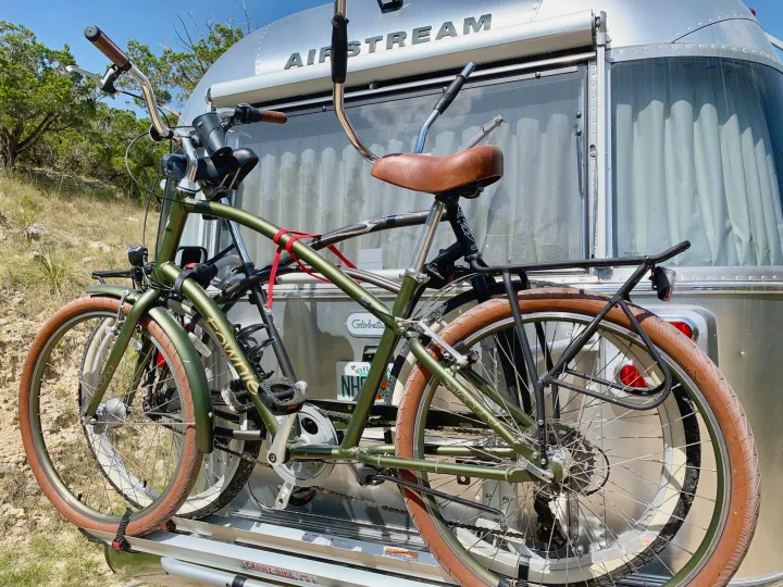Two bikes on a rack at the rear of an Airstream RV rental, ready for outdoor travel adventures.. Airstream Globetrotter 2020