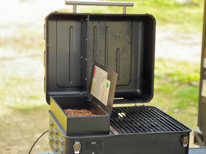 Open Traeger portable grill with wood pellets & grates, ready for grilling on your RV rental trip. Perfect campsite cooking.. Grand Design Transcend Xplor 2022