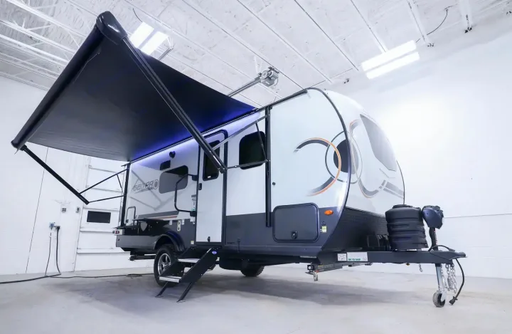 Bright indoor view of a modern gray and white travel trailer with illuminated awning for your rv rental.. Forest River Rockwood Geo Pro 2024