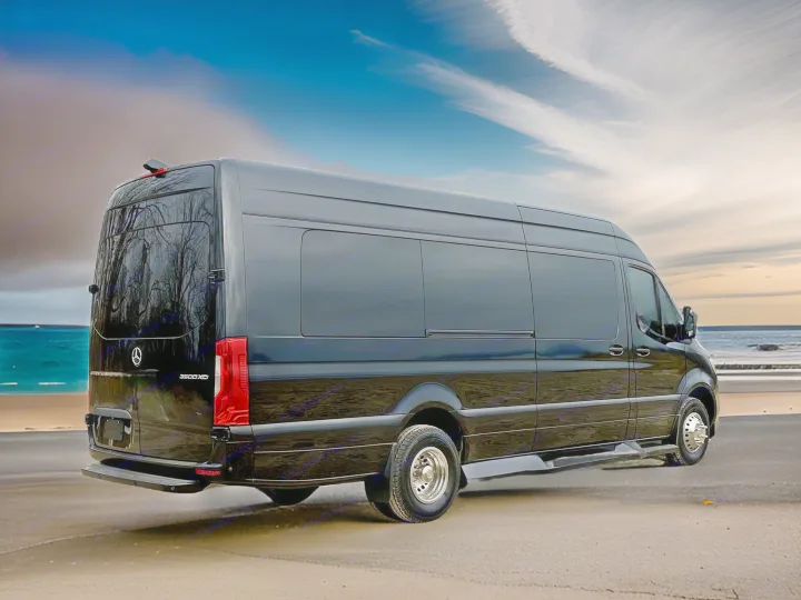 Luxury black Sprinter van, perfect for RV rental, parked on a beach road by the ocean under a cloudy sky.. Mercedes Benz Sprinter 3500XD 2024