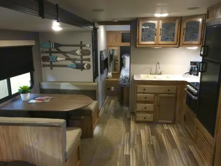 RV rental interior: dining area with paddle decor, full kitchen, and wood-look flooring.. Coachmen Freedom Express Ultra Lite 2019