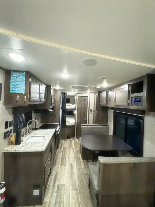 Spacious RV rental interior with kitchen, dining area, and bunk beds. Perfect for your next camping trip.. Jayco Jay Flight SLX 2021