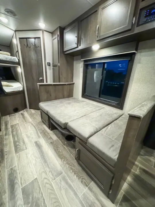 Experience comfortable travels with this RV rental's spacious interior, featuring a dinette, bunk beds, and ample storage.. Jayco Jay Flight SLX 2021