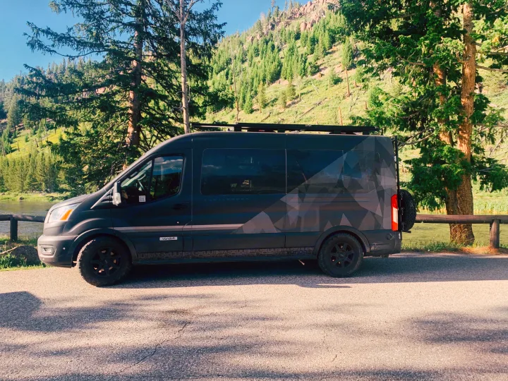 Discover nature with this dark gray adventure van, an ideal RV rental, by a river and green mountains.. Vandoit Vandoit Class B 2020