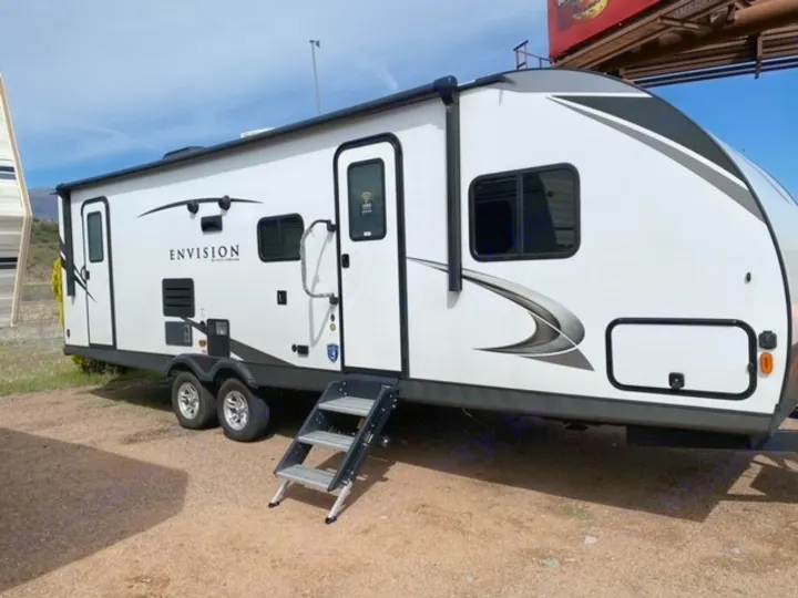 A spacious white Envision travel trailer RV rental, featuring an awning and extended entry steps.. Gulf Stream Gulf Breeze 2023