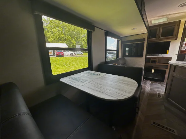Spacious RV rental interior with a cozy dining area, large windows offering scenic views, and a comfortable living space.. Highland Ridge RV Olympia 2022
