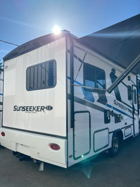 This bright white Sunseeker LE Forest River RV rental features blue graphics and an extended awning for your travels.. Forest River Sunseeker 2025