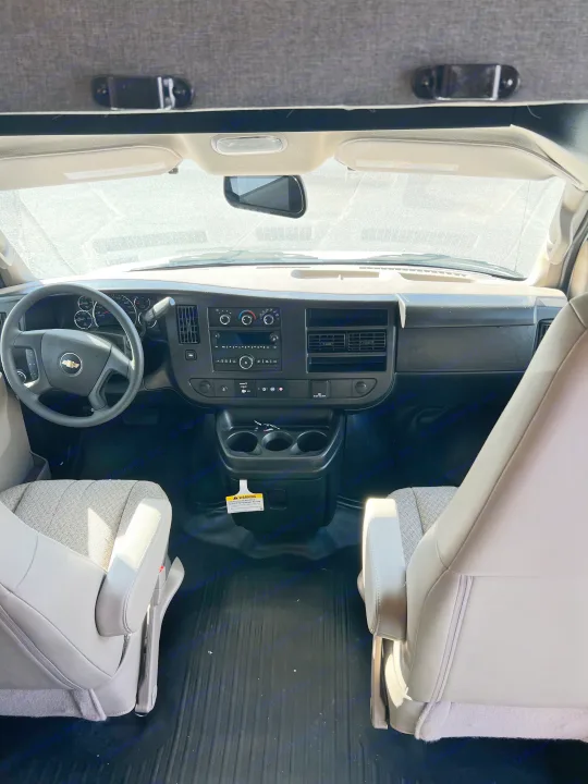 Interior view of an RV rental's front cabin, showcasing the dashboard, steering wheel, and seats.. Forest River Sunseeker 2025