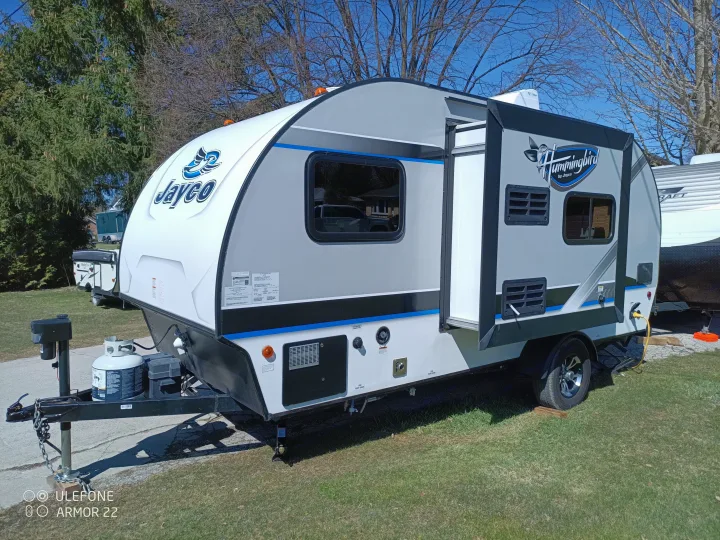 Jayco Hummingbird travel trailer in light gray and white with an open door, ready for your rv rental adventure.. Jayco Hummingbird 2018