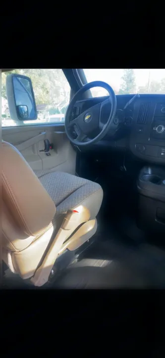 RV rental van interior: Chevrolet van cockpit view, showing steering wheel, dash, and tan seats from passenger side.. Thor Four Winds 2018