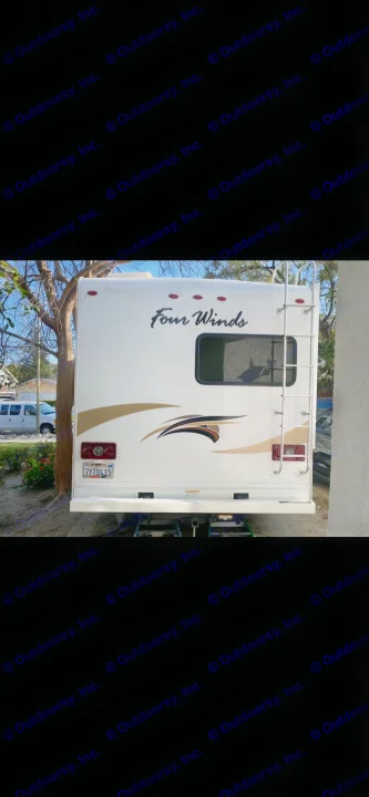 White Four Winds RV rental, rear view. Features a ladder, window, and decorative graphics. Ideal for travel.. Thor Four Winds 2018