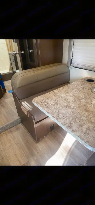 RV rental interior featuring a cozy dinette with a table and bench seating, ideal for meals & relaxation.. Thor Four Winds 2018