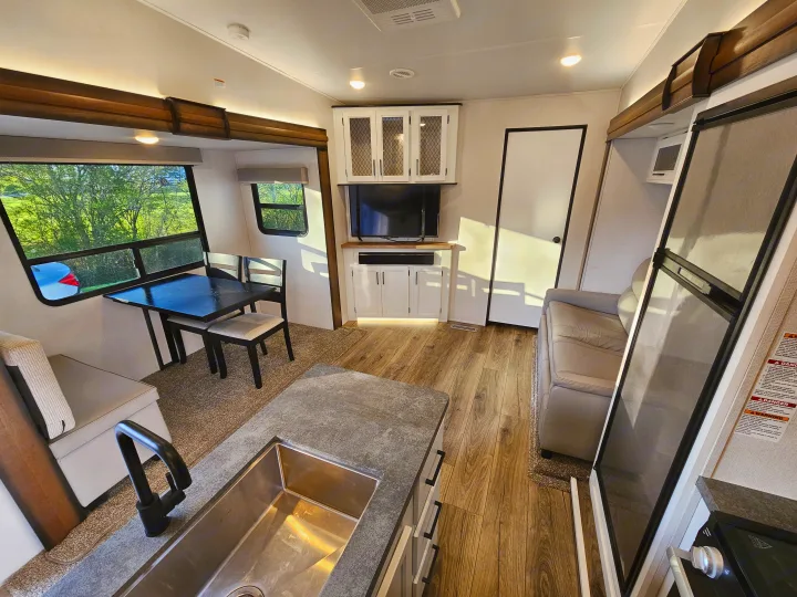 Experience a spacious RV rental interior: kitchen, dining, and living areas with large windows, modern finishes, and bright lighting for comfortable travel.. Crusader Lite 2022