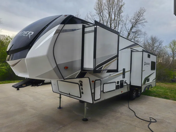A spacious Crusader Lite fifth-wheel RV, ready for an rv rental adventure, shown with slides extended on concrete.. Crusader Lite 2022