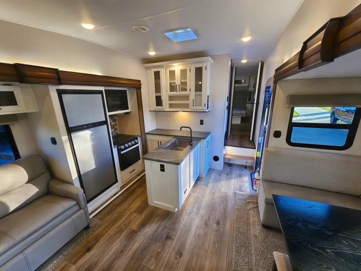 Experience a comfortable RV rental: modern kitchen, inviting living area with sofa and dining, plus access to sleeping quarters.. Crusader Lite 2022