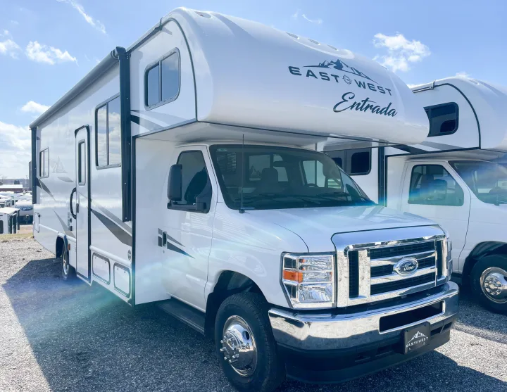 A gleaming white East to West Entrada Class C motorhome, perfect for an rv rental, parked under a clear sky.. East To West Entrada 2025