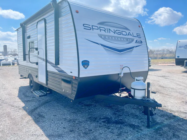 Front view of a Springdale Keystone RV travel trailer on a gravel lot, ready for adventure or your next rv rental.. Keystone Springdale Classic Mini 2024