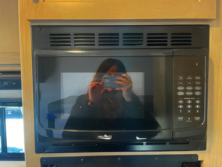 Modern High Pointe microwave in an RV rental kitchen. Features clear controls, an essential appliance for convenience.. Keystone Springdale Classic Mini 2024
