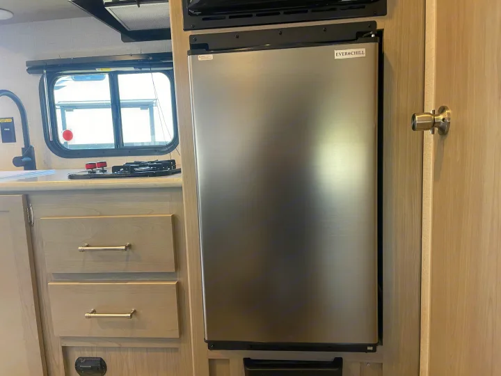 RV rental: Modern compact stainless steel fridge, sink, and two-burner stovetop in a light-toned kitchen space.. Keystone Springdale Classic Mini 2024