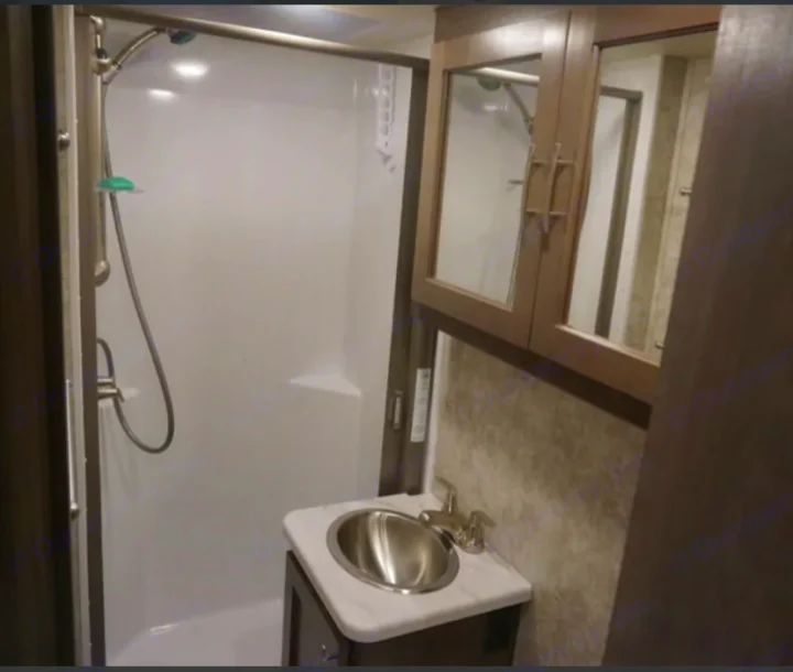 Functional RV rental bathroom featuring a compact shower, small sink with vanity, and overhead mirrored cabinet.. Adventurer Adventurer Motorhome 2019