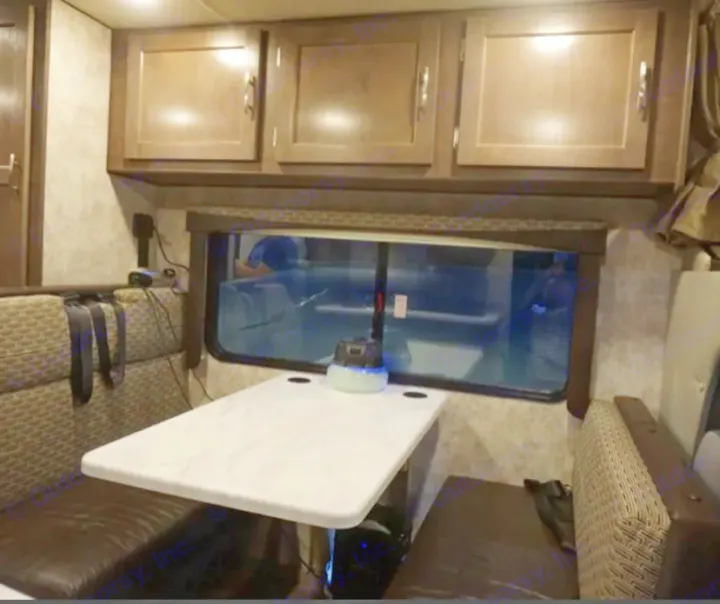 Cozy RV rental dinette featuring a table, plush benches, and overhead storage. Ideal for comfortable travel adventures.. Adventurer Adventurer Motorhome 2019